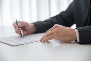 a lawyer holding a pen and reading a document placed on a white table